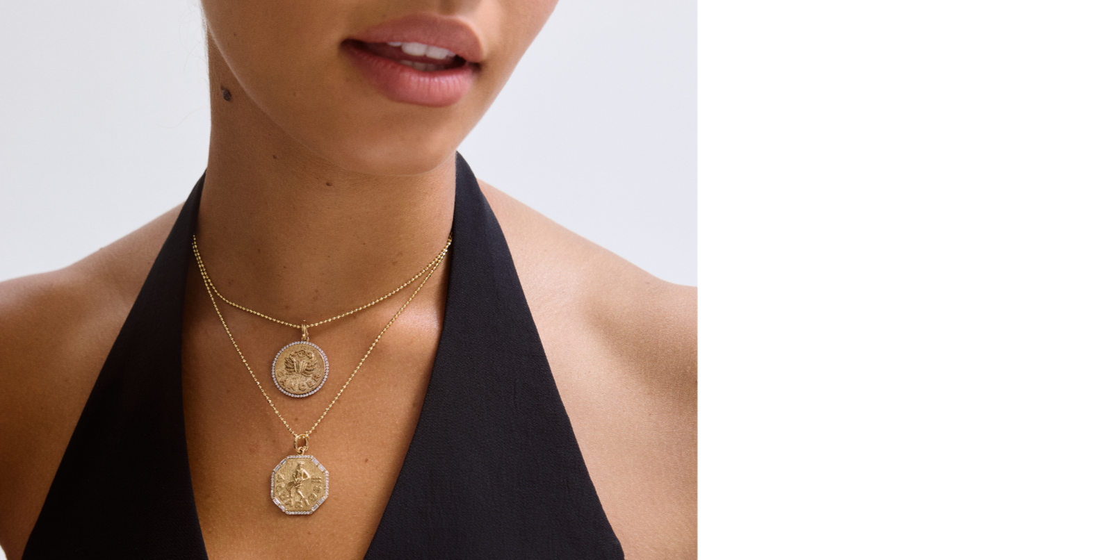 Woman wearing a gold necklace with circular 14k diamond zodiac pendants on a plain background