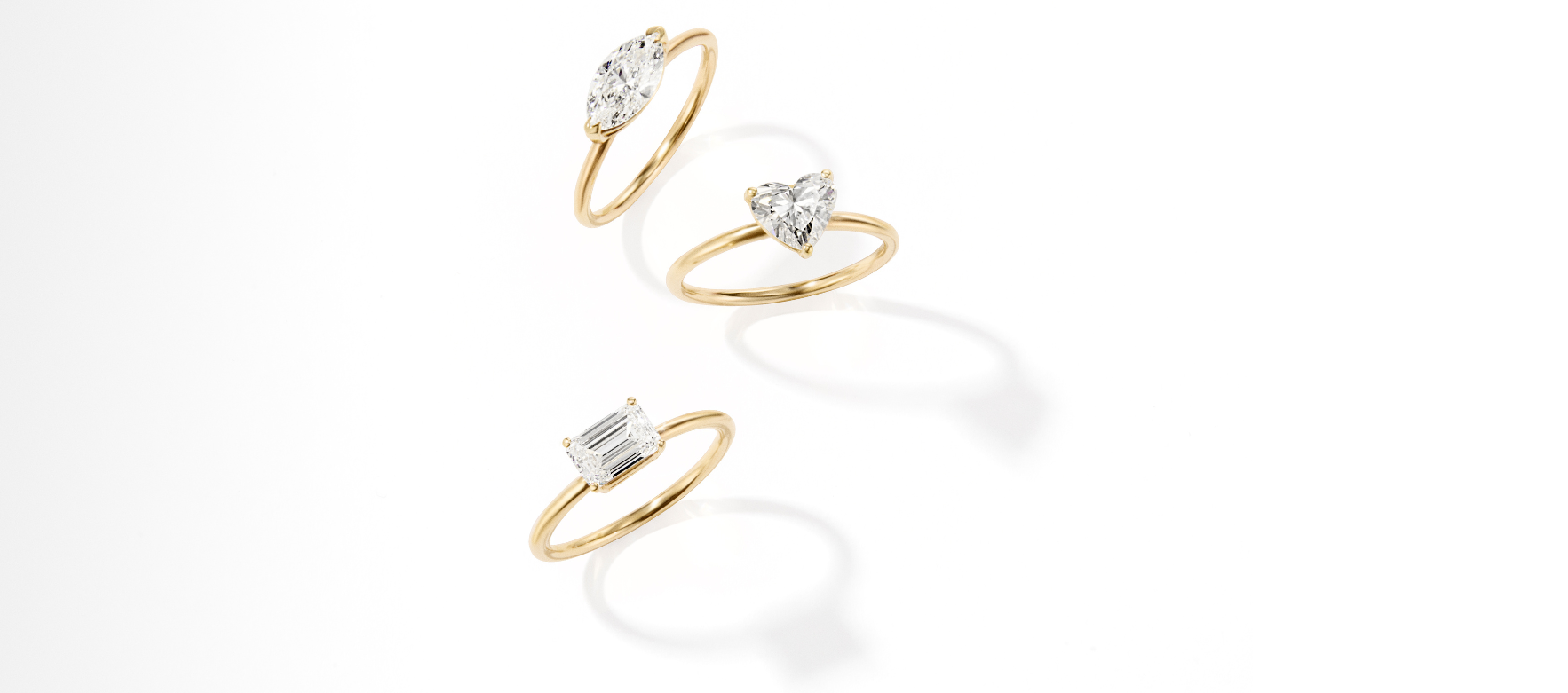 Three gold rings with diamond accents on a white background